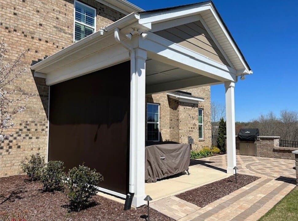 Dark retractable screen installed on a freestanding covered patio