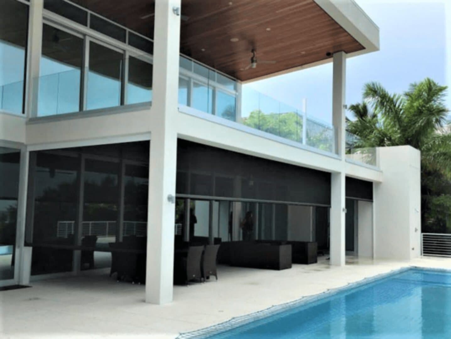 Large outdoor screens enclosing a modern poolside living area