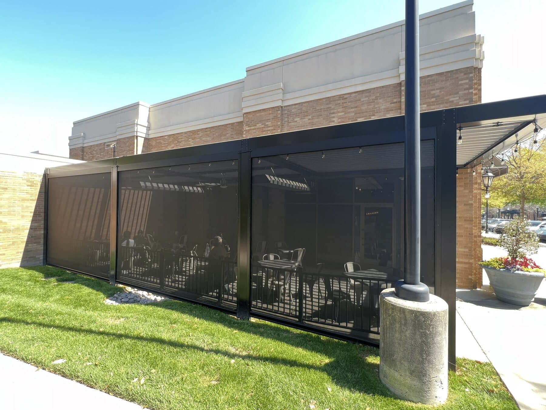Black insect screens enclosing the exterior of a restaurant patio