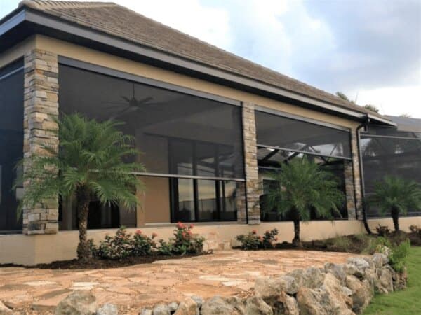 Insect screens installed between the stone columns of a covered porch