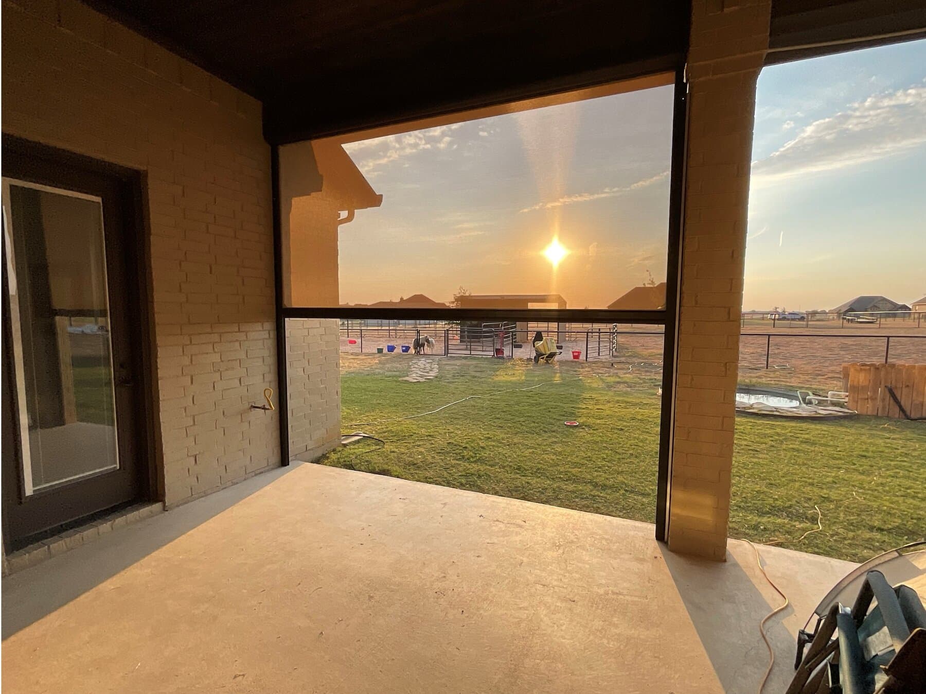Motorized patio screen filtering warm sunset light