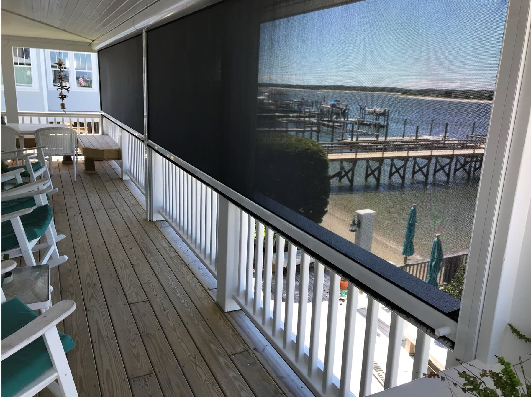 Outdoor screen installed on a waterfront balcony overlooking the docks