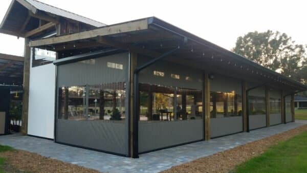 Outdoor screens enclosing a converted barn wedding venue